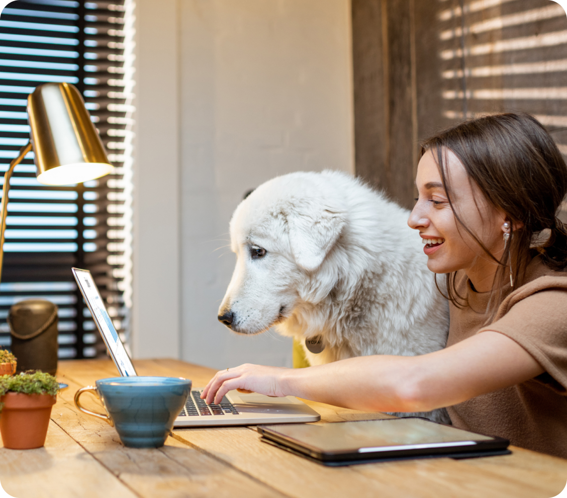 A woman and her dog looking at a computer.