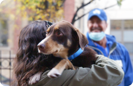 A woman holding her lost dog after being reunited.