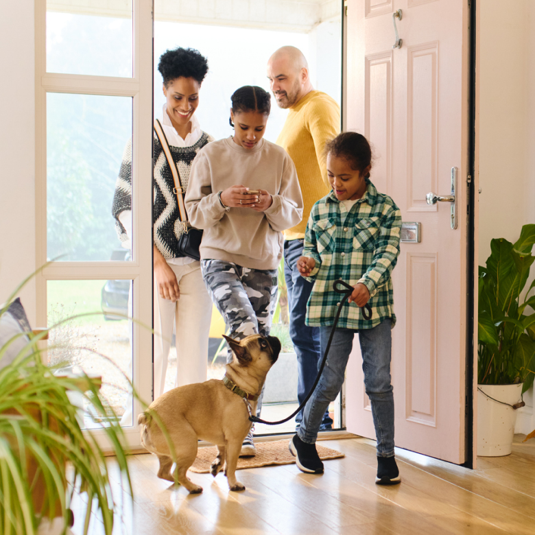 A family with their dog returning home from a walk.